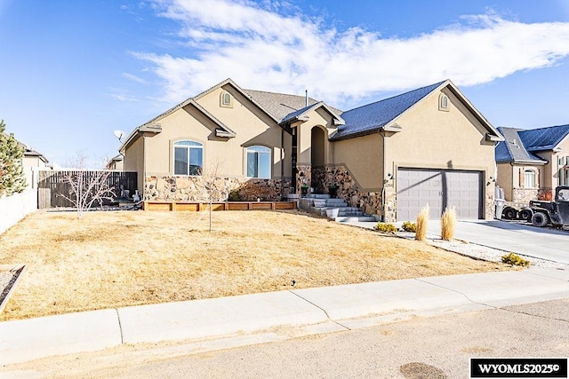 ranch-style house with stucco siding, an attached garage, fence, stone siding, and driveway