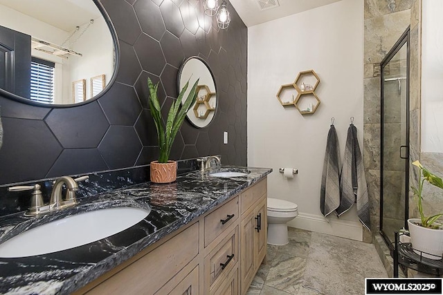 bathroom with marble finish floor, a sink, toilet, and a shower stall