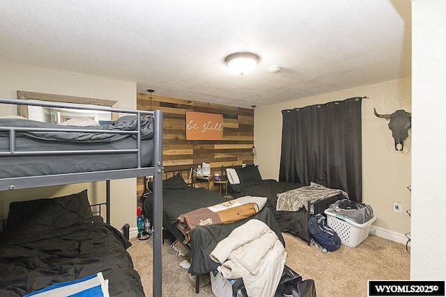 carpeted bedroom featuring wood walls