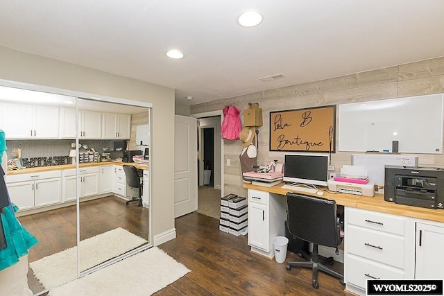 office featuring visible vents, dark wood finished floors, built in desk, and recessed lighting