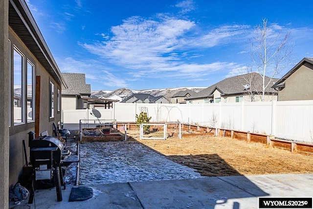 view of yard with a residential view, a garden, and a fenced backyard