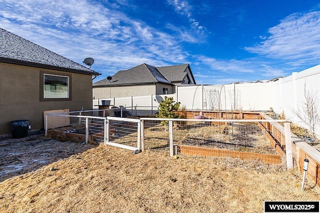 view of yard featuring fence and a garden