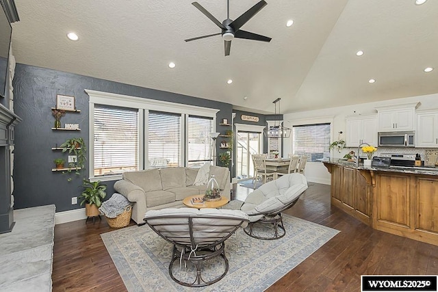 living room with dark wood-style floors, lofted ceiling, a ceiling fan, a textured ceiling, and baseboards