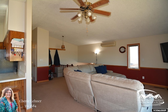 living room featuring light colored carpet, vaulted ceiling, a textured ceiling, ceiling fan, and a wall mounted air conditioner