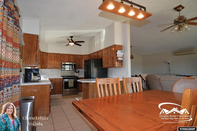 kitchen featuring light countertops, appliances with stainless steel finishes, brown cabinetry, light tile patterned flooring, and ceiling fan