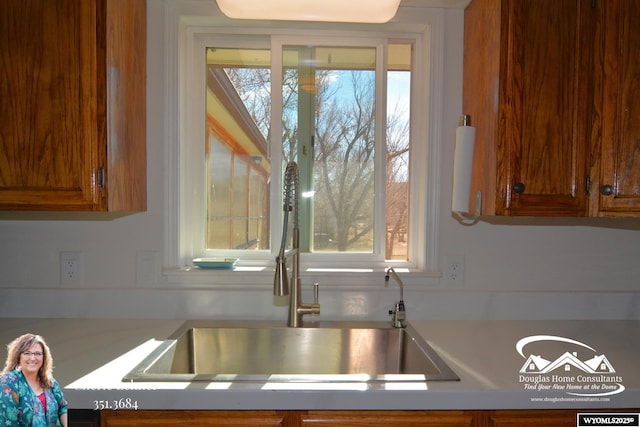 kitchen with light countertops, a sink, and a healthy amount of sunlight