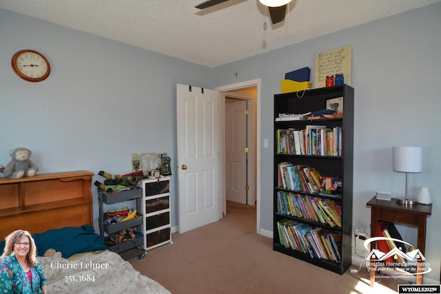 carpeted bedroom with a ceiling fan and a textured ceiling