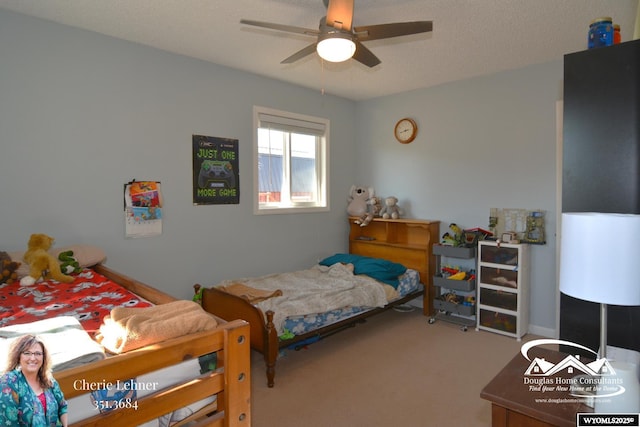 carpeted bedroom featuring ceiling fan and a textured ceiling