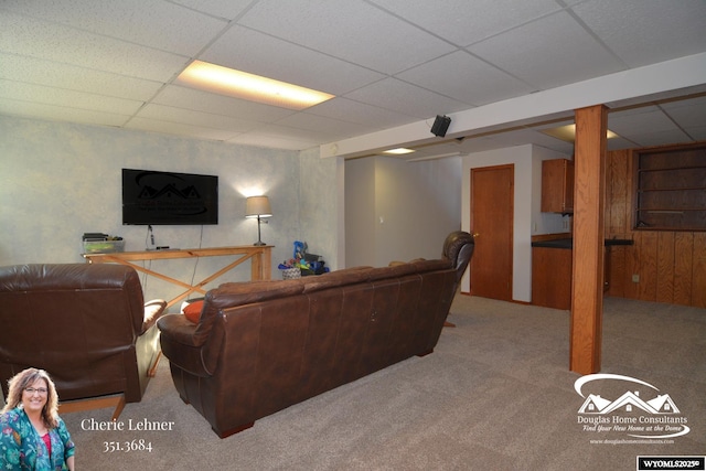 living room featuring a paneled ceiling and carpet flooring