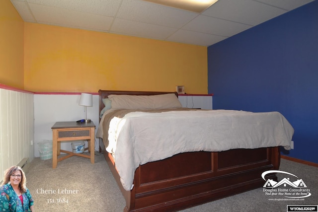 carpeted bedroom featuring a drop ceiling