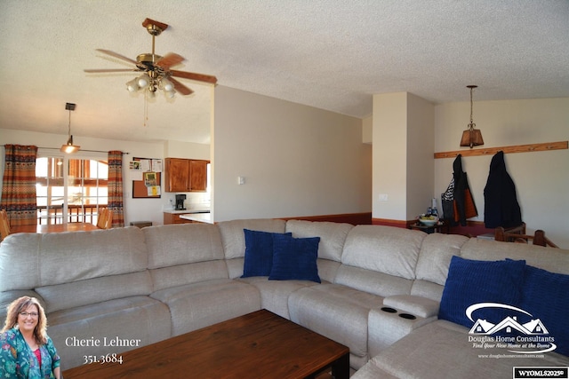 unfurnished living room with a ceiling fan, vaulted ceiling, and a textured ceiling