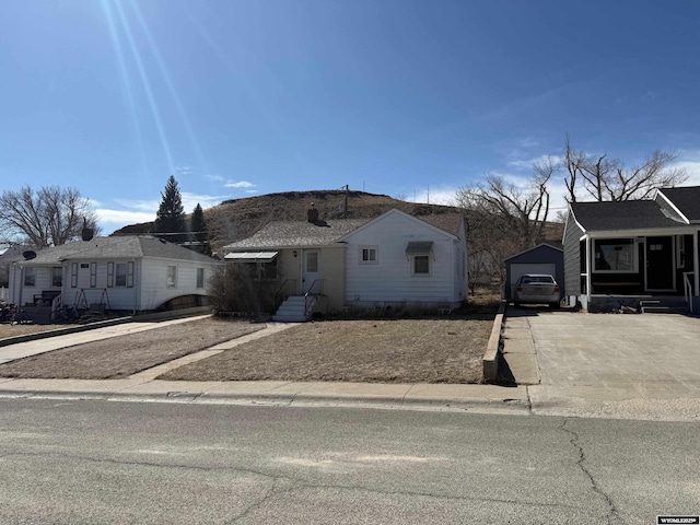 bungalow-style house with an outbuilding, concrete driveway, and a garage