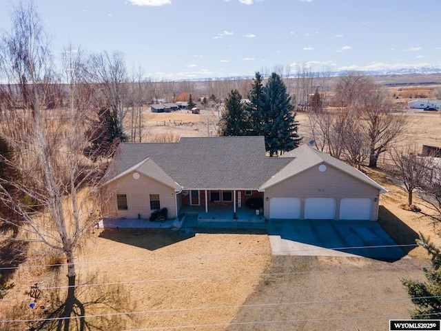 ranch-style house featuring covered porch, concrete driveway, and a garage