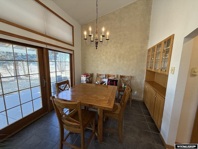 dining area featuring high vaulted ceiling, dark tile patterned floors, mail area, and an inviting chandelier