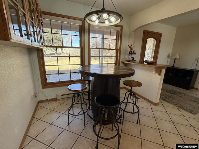 dining area with light tile patterned floors, plenty of natural light, and baseboards