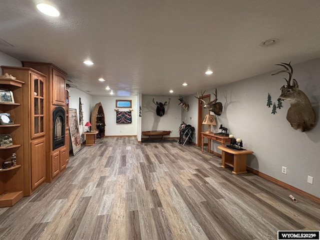 interior space featuring baseboards, a fireplace, light wood-style flooring, and recessed lighting