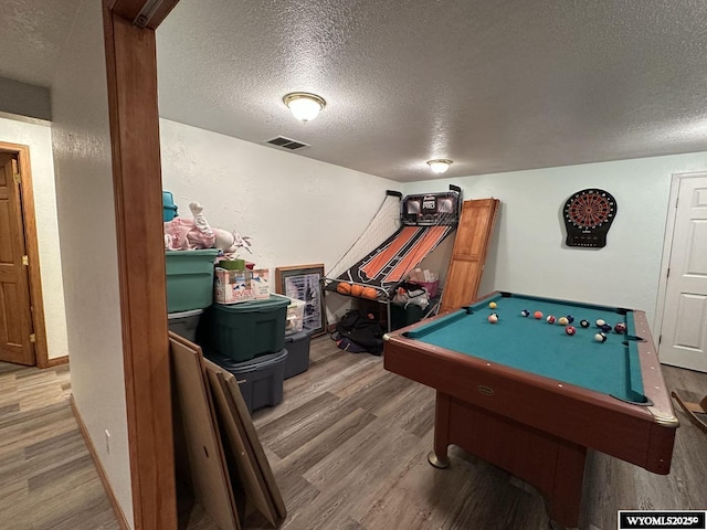 recreation room featuring visible vents, a textured ceiling, wood finished floors, billiards, and baseboards