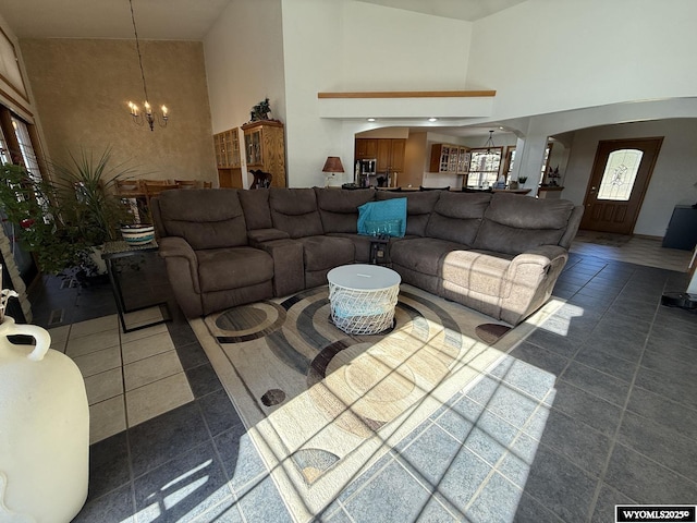 tiled living area with a high ceiling and an inviting chandelier