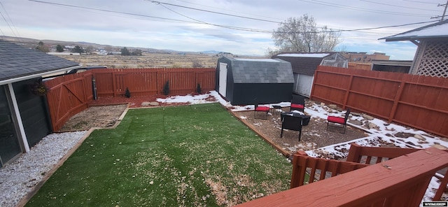 view of yard with an outbuilding, a fenced backyard, and a storage unit