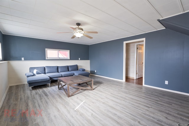 living area with ceiling fan, baseboards, and wood finished floors