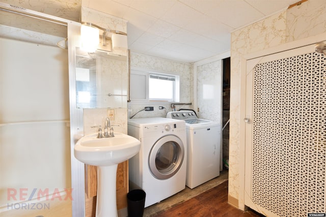 laundry room featuring laundry area, dark wood finished floors, a sink, and washing machine and clothes dryer