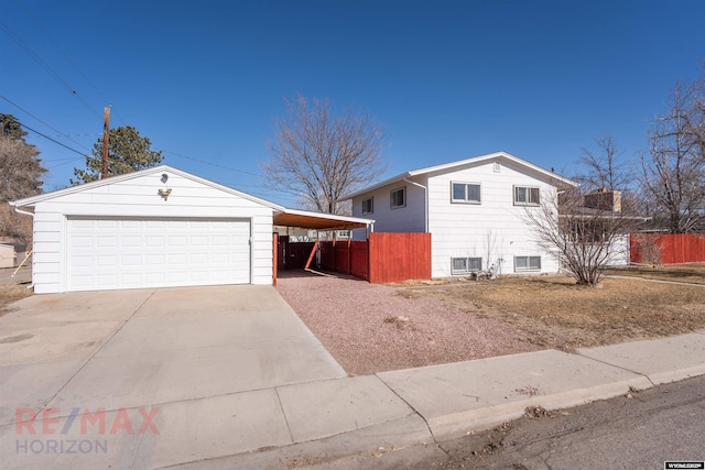 view of front of home featuring a carport, fence, driveway, and a garage