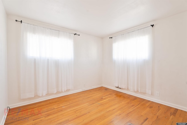 unfurnished room with wood-type flooring and baseboards