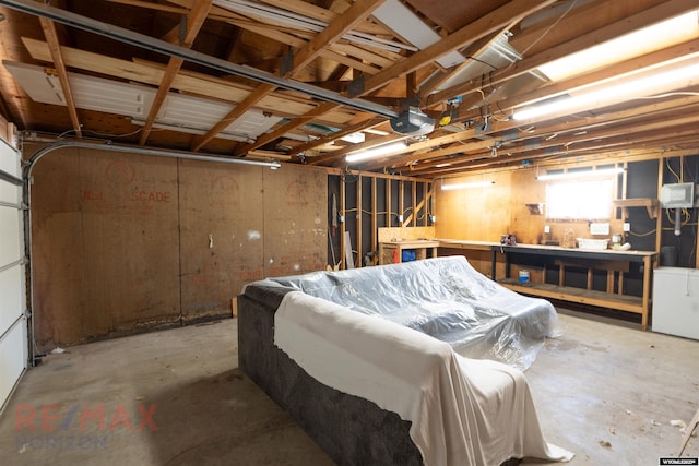 garage featuring fridge, a workshop area, and a garage door opener