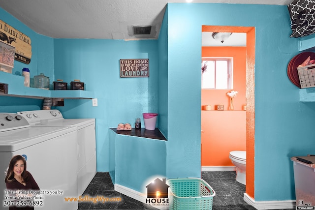 clothes washing area with a textured ceiling, washing machine and dryer, laundry area, visible vents, and baseboards