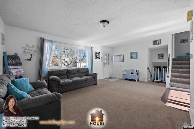 living room featuring carpet, a textured ceiling, baseboards, and stairs