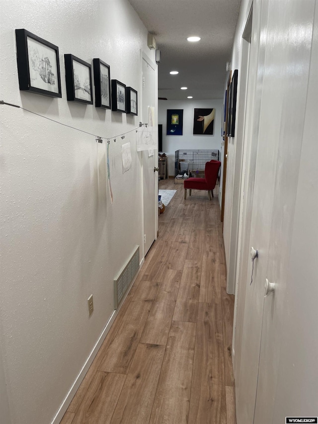 corridor with baseboards, visible vents, wood finished floors, and recessed lighting