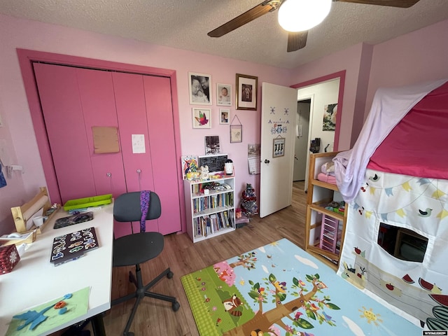 playroom featuring ceiling fan, a textured ceiling, and wood finished floors