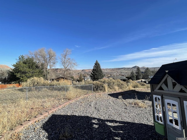 view of yard featuring fence and a mountain view