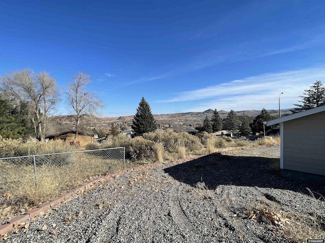 view of yard featuring fence and a mountain view