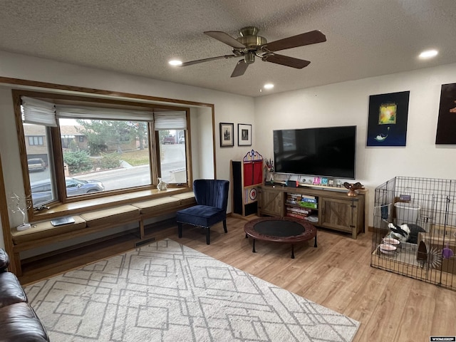 living room featuring a textured ceiling, wood finished floors, and recessed lighting