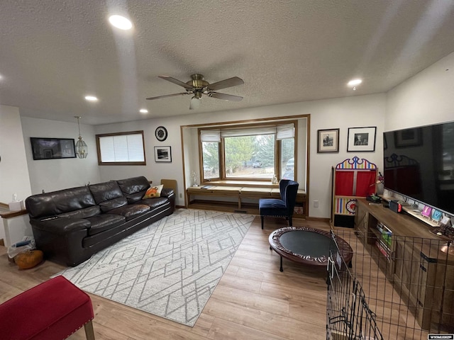 living area with baseboards, ceiling fan, wood finished floors, a textured ceiling, and recessed lighting