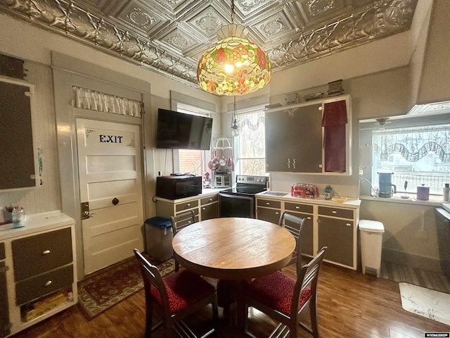 kitchen featuring stainless steel electric range oven, an ornate ceiling, black microwave, and dark wood-style flooring