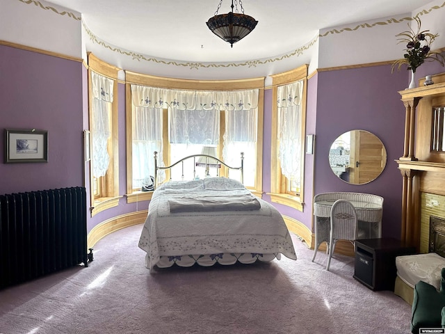 bedroom featuring carpet, a fireplace, and radiator heating unit