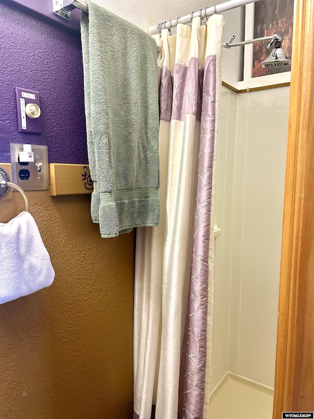 full bath featuring a shower with curtain and a textured wall