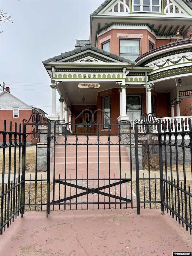 view of front of home featuring brick siding and fence