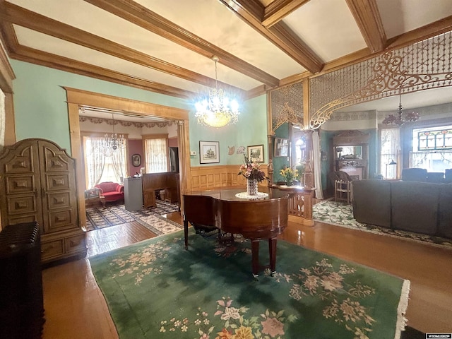 interior space featuring a notable chandelier, ornamental molding, wainscoting, wood finished floors, and beamed ceiling