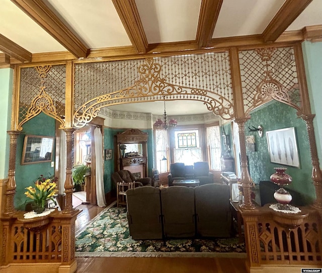 living area featuring ornamental molding, beamed ceiling, and wood finished floors