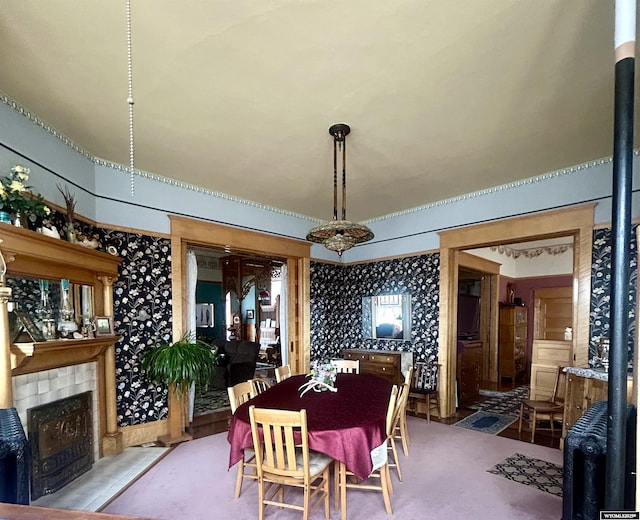 dining room with wallpapered walls and a fireplace