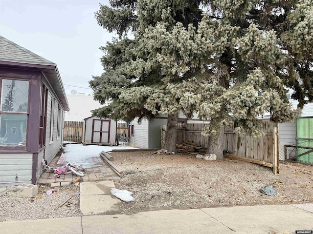 view of yard featuring an outbuilding, fence, and a shed