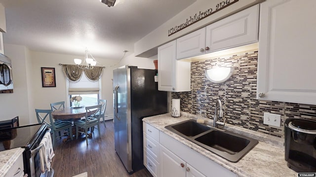 kitchen with white cabinets, dark wood-type flooring, stainless steel appliances, light countertops, and a sink