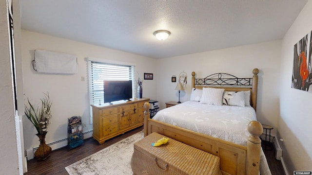 bedroom with a baseboard radiator and dark wood finished floors