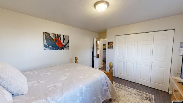 bedroom with a textured ceiling, a closet, and dark wood-style flooring