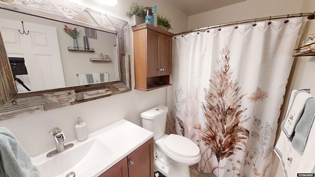 bathroom featuring a shower with shower curtain, vanity, and toilet