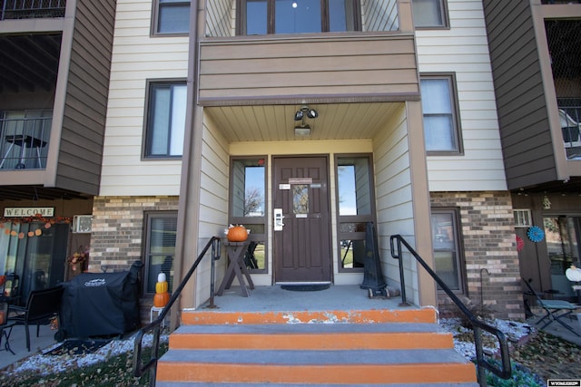 property entrance featuring brick siding