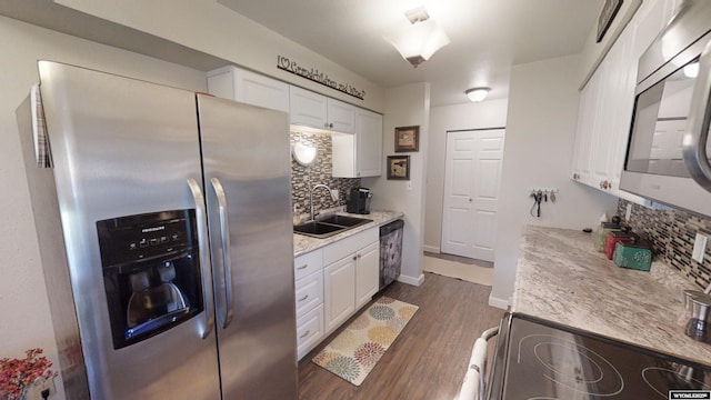 kitchen featuring dark wood finished floors, tasteful backsplash, appliances with stainless steel finishes, white cabinetry, and a sink